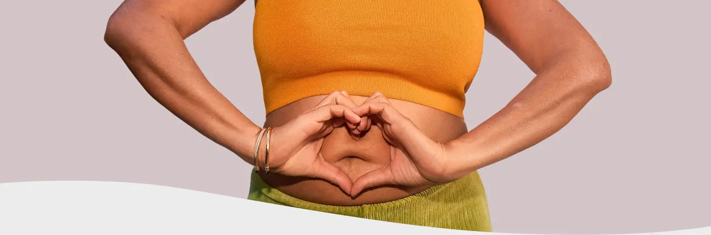 Mujer sonriendo sosteniendo su panza
