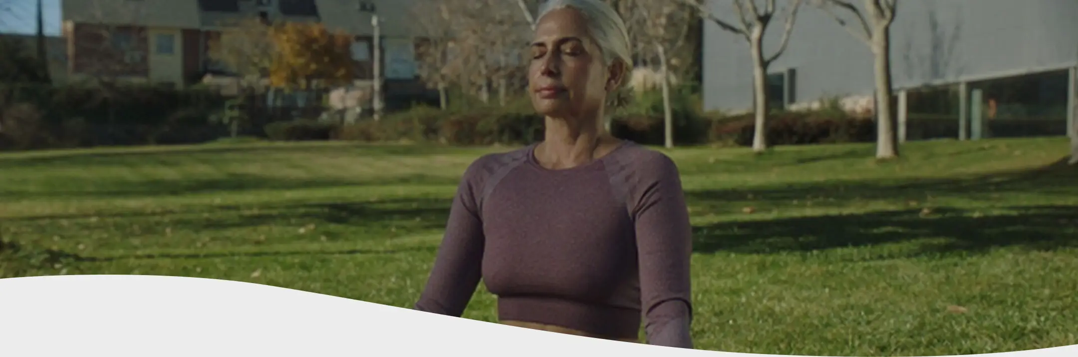 Mujer con camisa rosa sonriendo en su escritorio