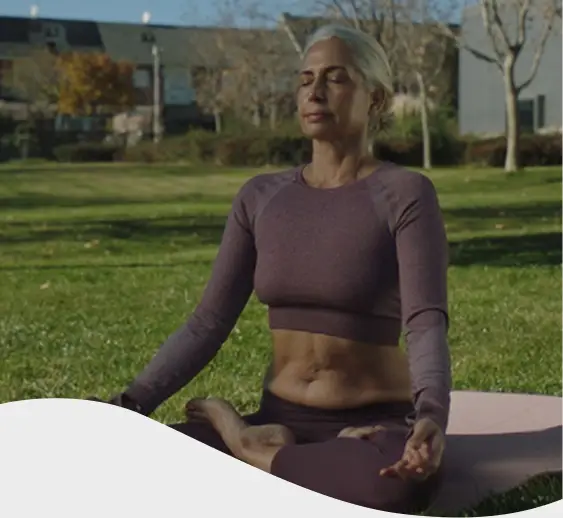 Mujer con camisa rosa sonriendo en su escritorio