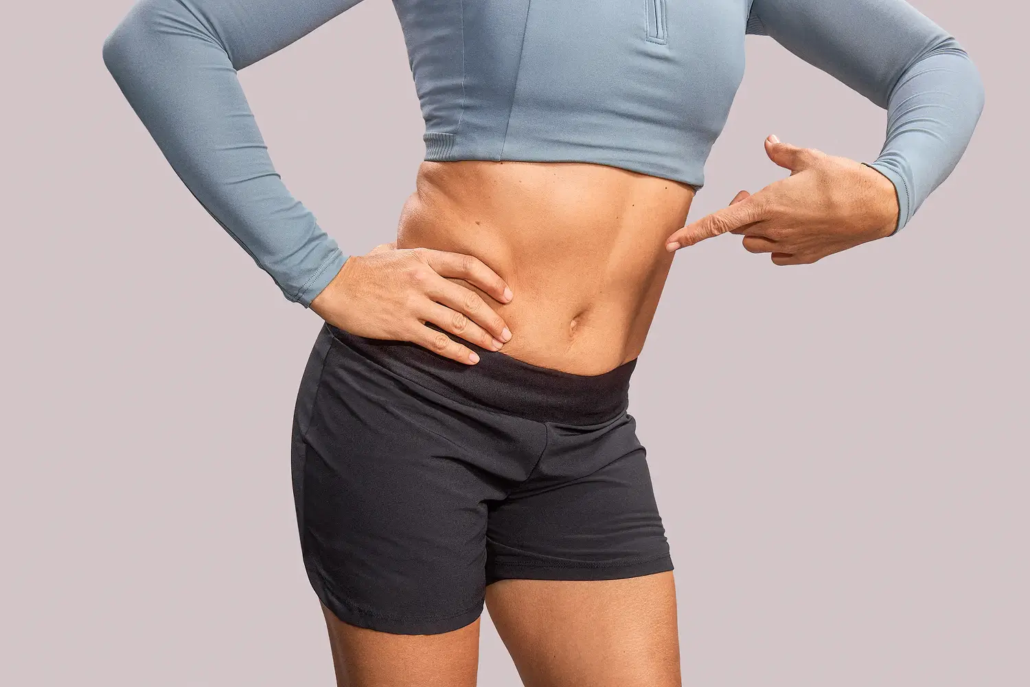 Mujer con camisa y saco con dolor agarrándose la panza