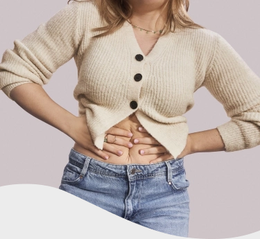 Hombre con chomba con cara de dolor mientras sostiene una hamburguesa y unas papas fritas