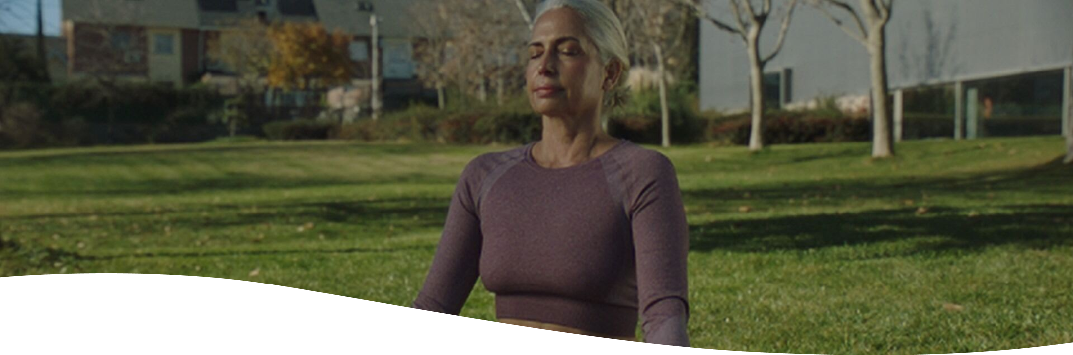 Mujer con camisa rosa sonriendo en su escritorio