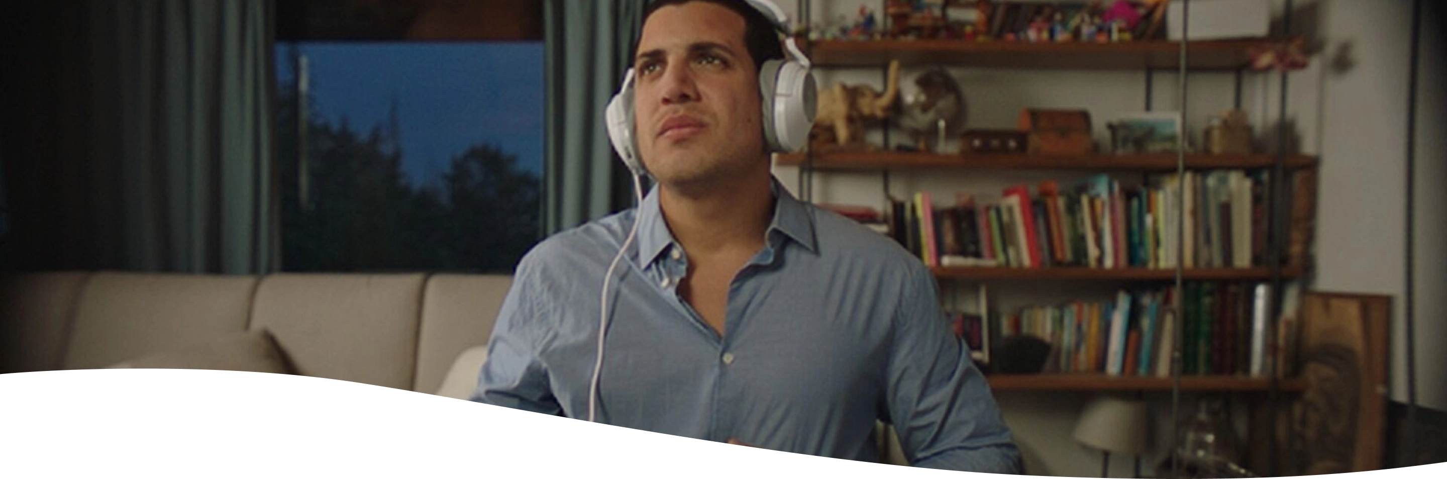 Hombre con chomba con cara de dolor mientras sostiene una hamburguesa y unas papas fritas