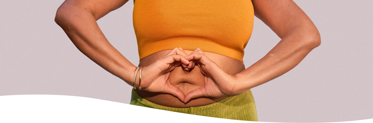 Mujer sonriendo sosteniendo su panza