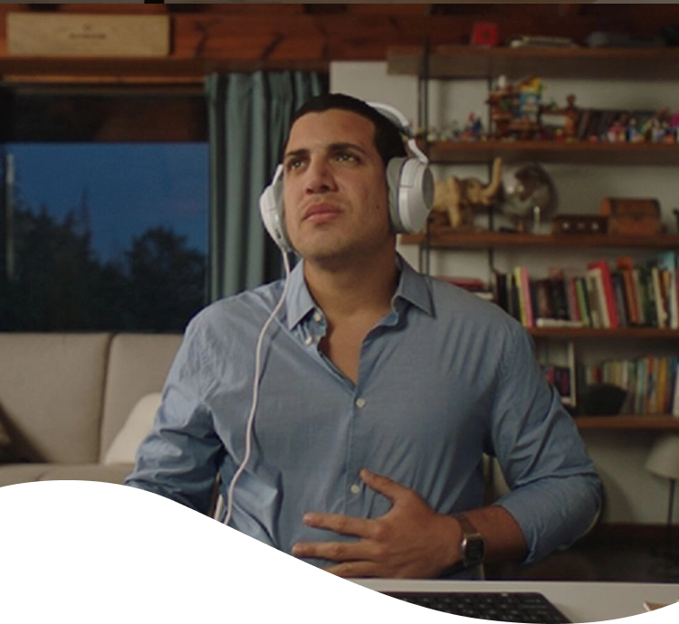 Hombre con chomba con cara de dolor mientras sostiene una hamburguesa y unas papas fritas