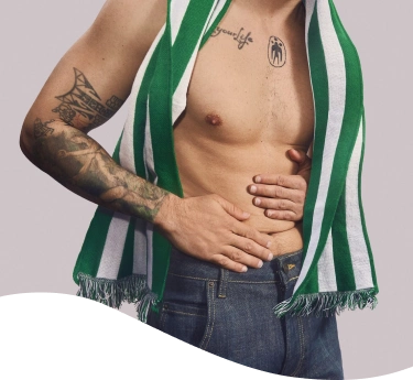 Hombre con chomba con cara de dolor mientras sostiene una hamburguesa y unas papas fritas