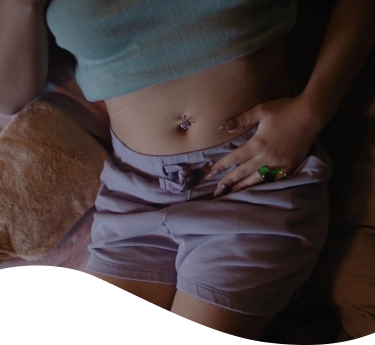 Mujer encorvada con cara de dolor sosteniéndose la panza
